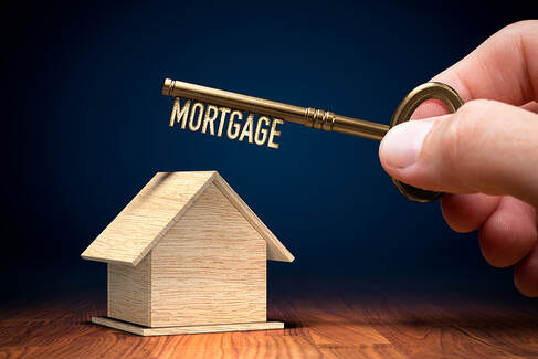 A wooden house and a key with the word mortgage written on it.